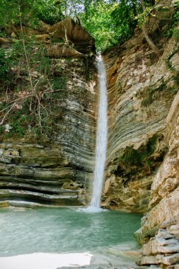 şelale yaz aylarında kayalarla çevrili