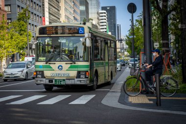 Osaka, Japonya - 4 Kasım 2025: Osaka, Japonya 'da Trafik Işığında Bekleyen Bisiklet Yüzlü Otobüs ve Kadın