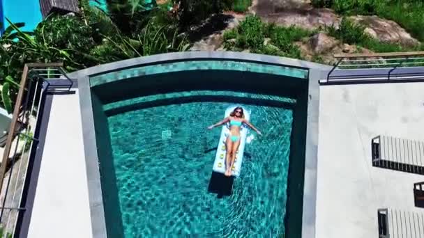 Girl swims in the pool on an air mattress — Stock Video