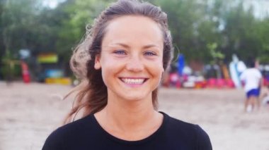 Sahilde günbatımı içinde gülümseyen kadın