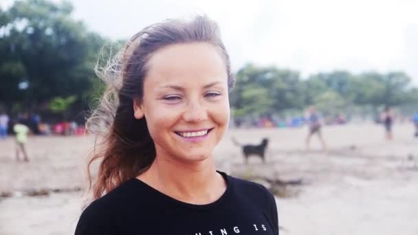 Kobieta uśmiechając się na plaży w zachód słońca — Wideo stockowe