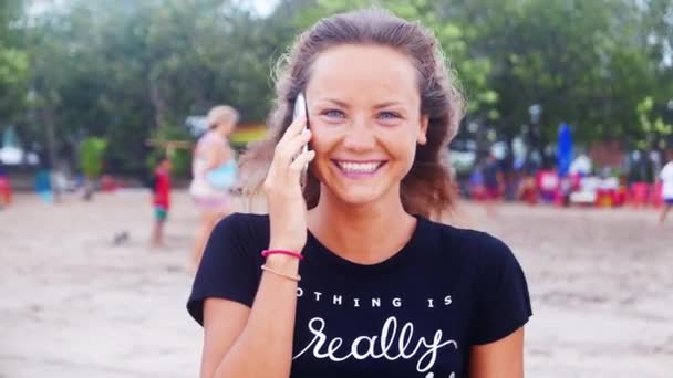 Mujer sonriendo en la playa al atardecer — Vídeo de stock