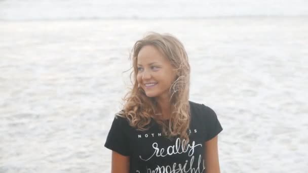 Женщина улыбается на пляже на закате — стоковое видео