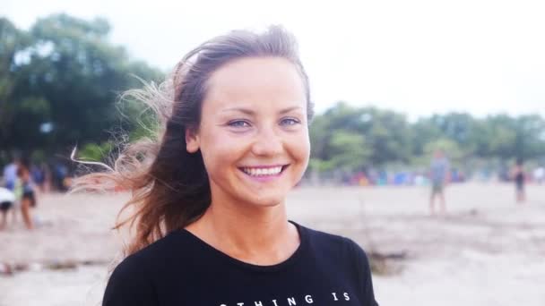 Mujer sonriendo en la playa al atardecer — Vídeos de Stock