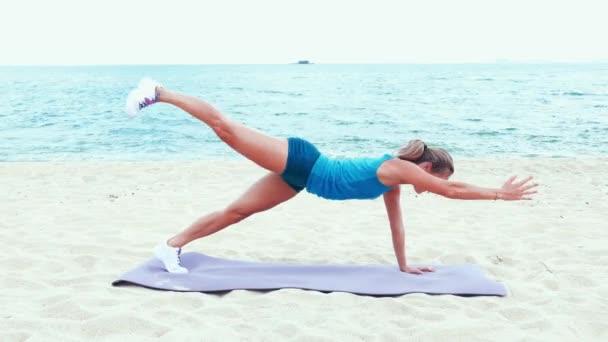 Woman stretching on beach — Stock Video
