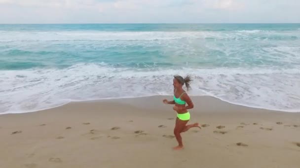 Vrouw joggen buiten op strand — Stockvideo