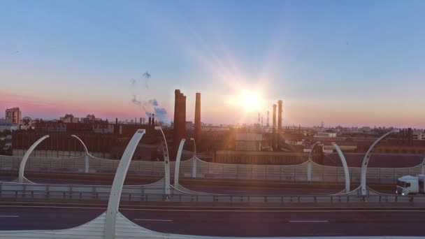 Курение промышленных труб и воздушный вид на шоссе на закате — стоковое видео