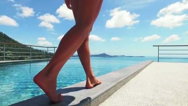 Mooie jonge vrouwelijke model met sexy benen relaxen aan het zwembad. Gelukkig brunette vrouw op reizen vakantie vakantie buitenshuis. — Stockvideo