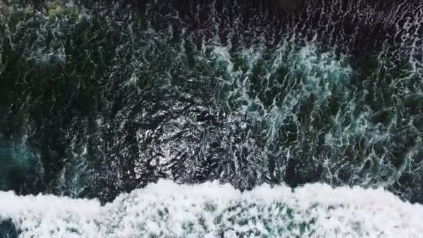 Au ralenti. Vue aérienne sur la plage de sable noir. Vagues énormes sur Bali, Indonésie 