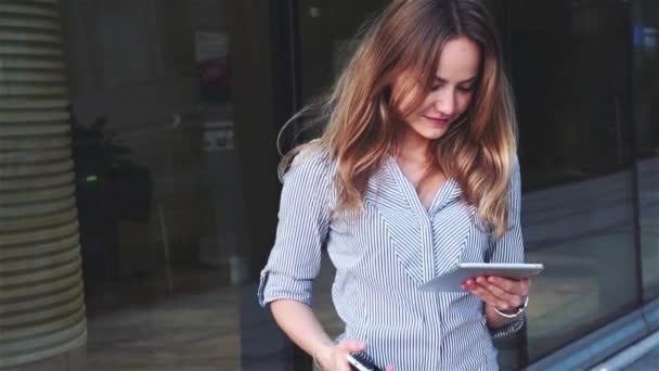 Vidéo de style cinématographique de belle femme d'affaires avec mobile et tablette sur le fond du centre d'affaires — Video