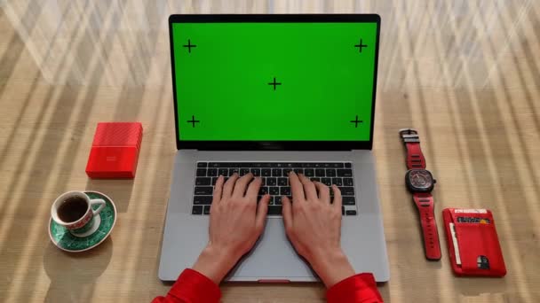 Προβολή παραπάνω γυναικεία χέρια πληκτρολογώντας στο laptop με διαφορετικά πράγματα κόκκινο χρώμα στο τραπέζι. Γυναίκα κάθεται κοντά σε παράθυρα με laptop και εργασίας. — Αρχείο Βίντεο