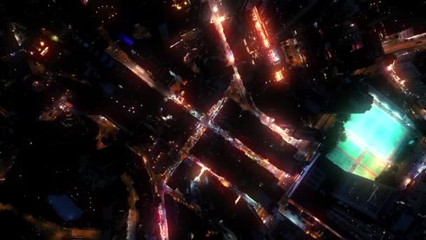 AERIAL. Blick von oben auf die nächtliche Innenstadt mit Wolkenkratzern und Neonbeleuchtung der Straßen — Stockvideo