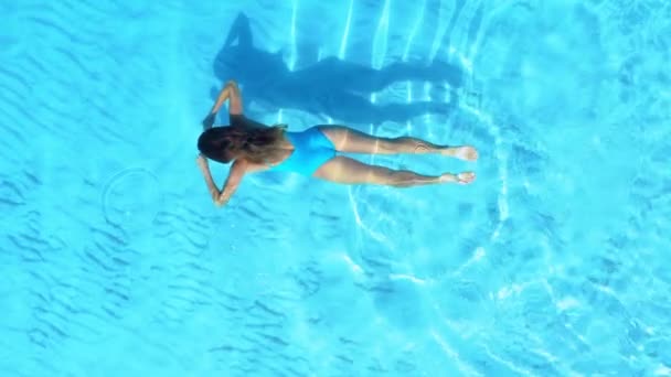 航空機だ。若い美しい女性が休暇中に澄んだ水の下で泳ぐ。女性とクリスタル海の水のドローンショット. — ストック動画
