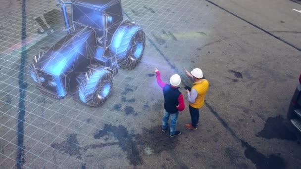 Deux travailleurs discutent d'un projet du nouveau tracteur utilisant un équipement holographique futuriste. — Video