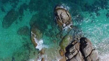 Tayland 'daki güzel plajın üzerinde uçmak, volkanik kayaların üzerinde havadan uçmak. Açık su güneşli gün.