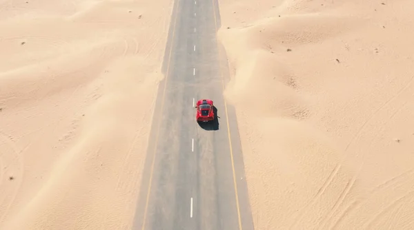 2019 Agosto, Dubai. Vista aérea Carro de corrida vermelho andando na estrada do deserto nos Emirados Árabes Unidos. — Fotografia de Stock