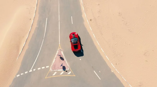 2019 August, Dubai. Aerial view Red race car riding on the desert road in UAE. — Stock Photo, Image