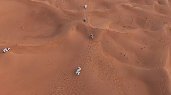 AERIAL. Column of white cars travelling in sand desert. — Stock Photo, Image