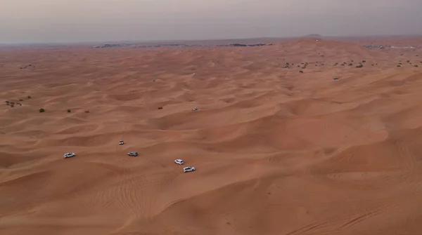 AERİAL. Kum çölünde giden beyaz arabalardan oluşan bir kolon.. — Stok fotoğraf