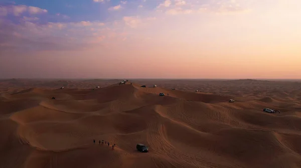 AERIAL. Kolonne weißer Autos in Sandwüste unterwegs. — Stockfoto