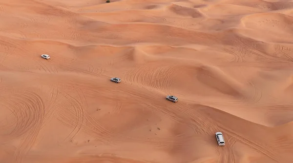 AERIAL. Coluna de carros brancos que viajam no deserto de areia. — Fotografia de Stock