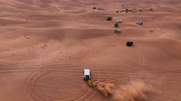 AERIAL. Column of white cars travelling in sand desert. — Stock Photo, Image