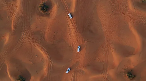 AERIAL. Колонна белых машин, путешествующих по песчаной пустыне. — стоковое фото