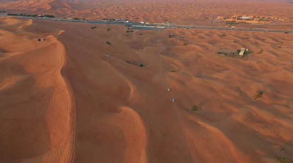 AERIAL. Columna de coches blancos que viajan en el desierto de arena. — Foto de Stock