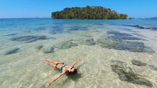 Mujer joven acostada en la playa. Modelo de moda posando en una isla tropical en gafas de sol. — Foto de Stock