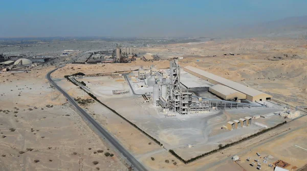 AERIAL. Draufsicht auf die Industrieproduktion in den VAE. Riesige Zementfabrik in der Wüste. — Stockfoto