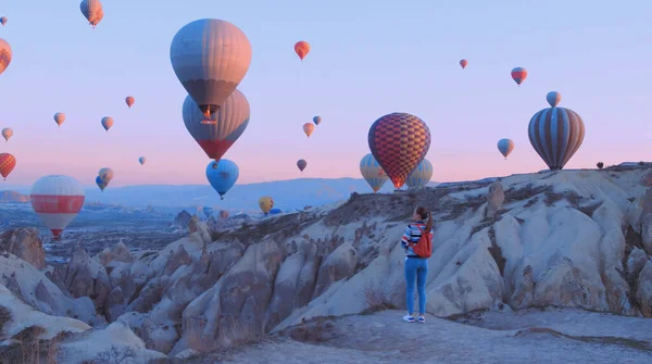 Viajante feminino com mochila olhando para os balões de ar. Menina desportiva e um monte de balões de ar quente. O sentimento de completa liberdade, realização, realização, felicidade — Fotografia de Stock