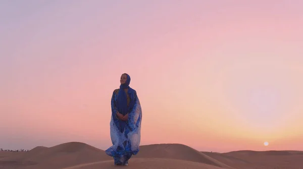 Πορτρέτο της όμορφης αραβικής γυναίκας φορούσε μπλε παραδοσιακό φόρεμα στην έρημο κατά τη διάρκεια του ηλιοβασιλέματος. — Φωτογραφία Αρχείου