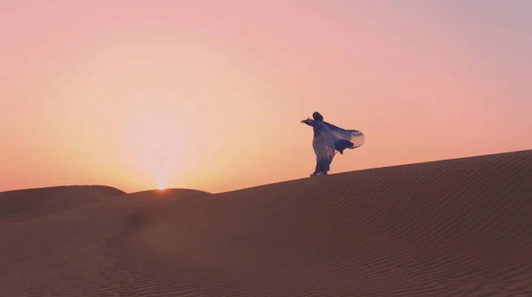 Retrato da bela mulher árabe vestida em azul vestido tradicional no deserto durante o pôr do sol. — Fotografia de Stock