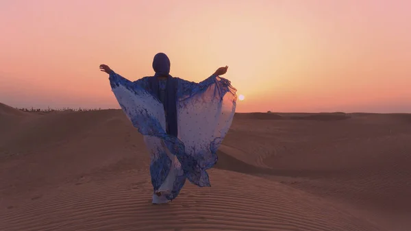 Портрет вродливої арабської жінки, одягненої в синє традиційне вбрання в пустелі під час заходу сонця.. — стокове фото