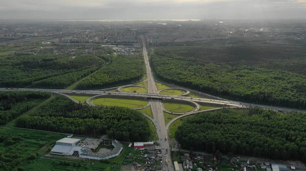 Аріале. Обмін трафіком. Вид зверху на дорогу, місто та ліс. Літнє відео з дрона . — стокове фото