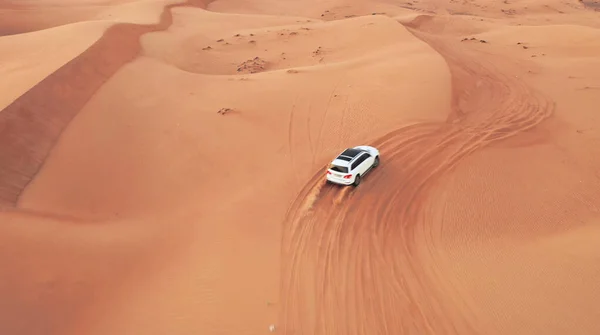AERIAL. Hight flight above car. Desert safari car sand dunning in the Dubai desert during sunset Stock Image
