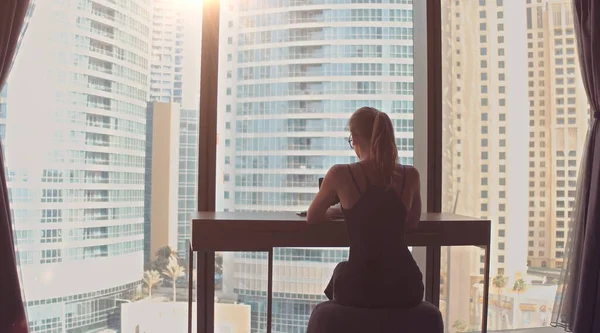 Güzel Başarılı İş Kadını Ofisinde Dizüstü bilgisayarında Şehir Manzarası Penceresi ile çalışıyor. Güçlü Bağımsız Kadın CEO İşletme Yöneticisi. 