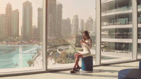 Businesswoman and large window in office building — Stock Photo, Image