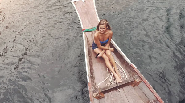 Mode de vie d'une belle voyageuse assise dans un bateau en bois sur fond de roches calcaires tropicales. Explorez et publiez le concept. Lac Khao Sok, Thaïlande. — Photo