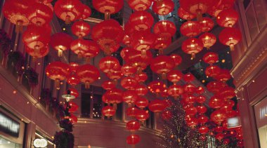 Kırmızı yanan Çin fenerleri bir şehir caddesi boyunca havaya yükseliyor.