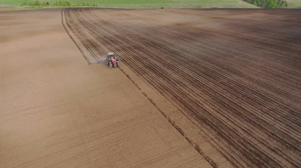 Luchtfoto van de trekker in het veld, veldwerk in de landbouw, zaaien in het veld bij zonsondergang — Stockfoto