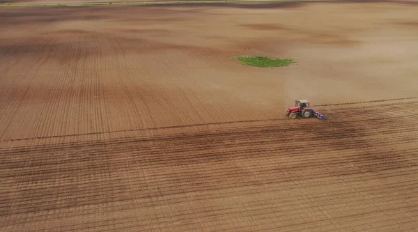 Luchtfoto van de trekker in het veld, veldwerk in de landbouw, zaaien in het veld bij zonsondergang — Stockfoto