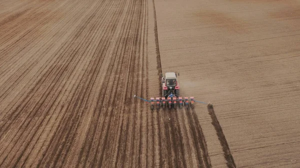 Luchtfoto van de trekker in het veld, veldwerk in de landbouw, zaaien in het veld bij zonsondergang — Stockfoto