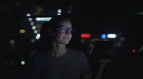 Gözlüklü kadın pencerenin yanında video konferansında konuşuyor. Arkaplanda Bokeh