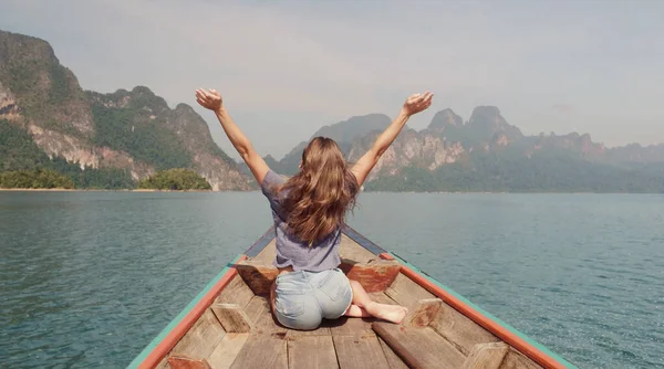 Genç Mutlu Karışık Yarış Kızı Khao Sok Gölü 'nde geleneksel Tayland Tahta Teknesinde oturup dinleniyor. Phang Nga Eyaleti, Tayland.