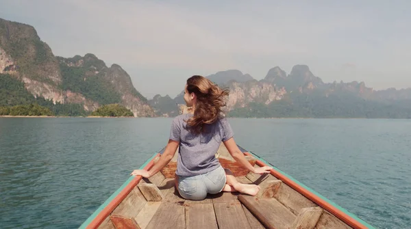 Genç Mutlu Karışık Yarış Kızı Khao Sok Gölü 'nde geleneksel Tayland Tahta Teknesinde oturup dinleniyor. Phang Nga Eyaleti, Tayland.