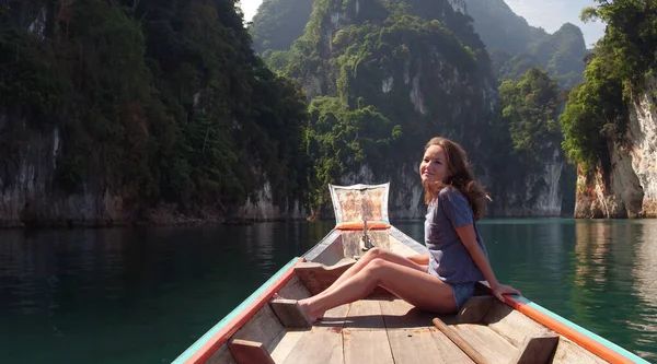Genç Mutlu Karışık Yarış Kızı Khao Sok Gölü 'nde geleneksel Tayland Tahta Teknesinde oturup dinleniyor. Phang Nga Eyaleti, Tayland.