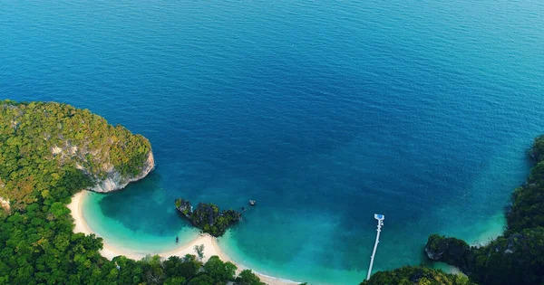 AIR. Vista dall'alto delle scogliere della laguna di spiaggia turchese dell'isola tropicale bianca e delle isole all'orizzonte di Krabi, la spiaggia o vista dall'alto da due barche a coda lunga sull'acqua color smeraldo — Foto Stock