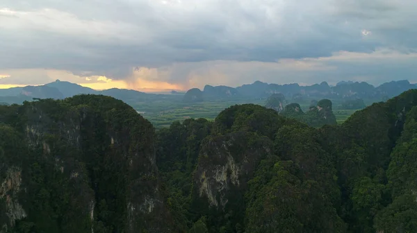 AERIALNE. Epicki i dramatyczny widok na góry w południowej części Tajlandii po zachodzie słońca i przed deszczem. Kamera poruszająca się nad szczytami gór, ogromne chmury. — Zdjęcie stockowe