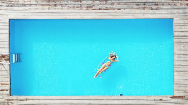 Style de vie en plein air portrait de jeune jolie fille sexy flottant avec matelas lumineux néon près de la piscine — Photo